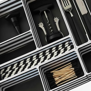 May include: A black and white striped organizer filled with various kitchen utensils. Items include a wine bottle stopper, a corkscrew, a fork, a knife, and toothpicks. The organizer has a modern design with a black and white color scheme.