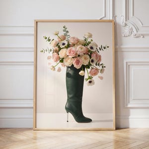 May include: A framed print featuring a tall, dark green leather boot filled with a bouquet of pink and white roses, anemones, and greenery. The boot has a stiletto heel. The background is a neutral color.