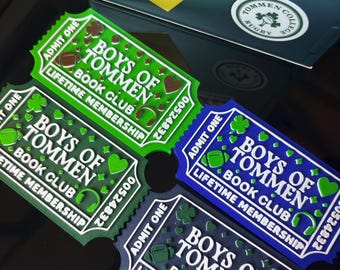 Può includere: Quattro targhe rettangolari a forma di biglietto con la scritta Boys of Tommen Book Club Lifetime Membership. Ognuna presenta il testo Admit One, un numero di serie 00524832 e icone di trifogli, cuori, palloni da rugby e cuffie in verde e blu.