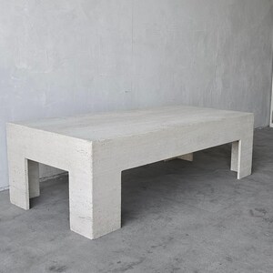 May include: A white rectangular coffee table with a simple, modern design. The table has a smooth, textured surface and four legs.