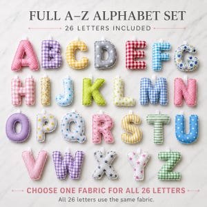 May include: A full A-Z alphabet set of 26 plush fabric letters. Each letter features a unique pattern including gingham, polka dots, stripes, stars, and floral prints in various colours. Each letter has a small white fabric loop at the top.