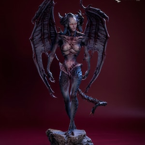 May include: A detailed sculpture of a winged demonic figure with horns, standing on a rocky base. The figure has a pale complexion, red eyes, and intricate body details. The wings are large and textured, and the tail is serpentine. The sculpture is on a black base.