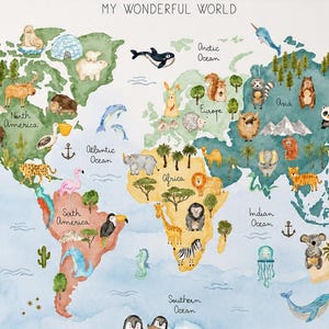 Op de afbeelding: Een ingelijste wereldkaart met de titel MY WONDERFUL WORLD, met aquarelcontinenten in tinten groen, geel en roze. De kaart is versierd met diverse geïllustreerde dieren, bomen en zeedieren die over de hele wereld zijn geplaatst.