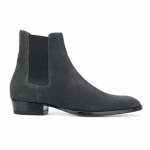 May include: A charcoal grey suede Chelsea boot featuring a smooth, rounded toe, a high ankle shaft, and a black elastic side panel. The boot is set on a low, stacked black heel with a sleek, polished black outsole that extends along the base.