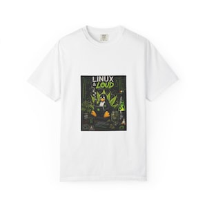 May include: White t-shirt featuring a graphic with a penguin using a laptop, surrounded by cannabis leaves and a lava lamp. The text "LINUX & LOUD" is displayed above the penguin. The design has green, black, and yellow accents.