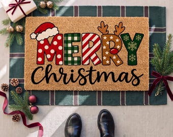 May include: A rectangular tan coir doormat featuring the text MERRY in large, multi-patterned letters including red polka dots, green plaid, red stripes, and brown reindeer antlers, with the word Christmas written in black cursive script below.