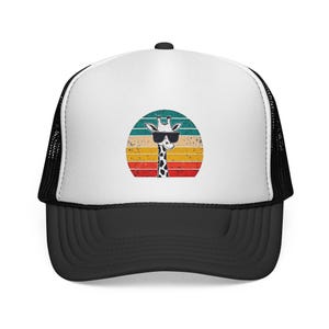 Puede incluir: Una gorra de camionero blanca y negra con un gráfico de una jirafa con gafas de sol negras centrado en el panel frontal. La jirafa está situada frente a un diseño circular de puesta de sol con rayas horizontales en color verde azulado, naranja y rojo.