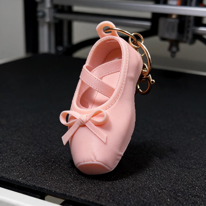 Puede incluir: Un llavero de zapatilla de ballet rosa claro con un acabado mate y suave. El zapato en miniatura tiene un lazo decorativo en la parte delantera, tiras cruzadas sobre la abertura y est&aacute; unido a una anilla de metal dorado para llaves.