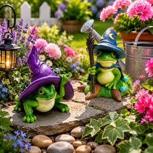 Könnte beinhalten: Zwei grüne Froschfiguren in einem Garten. Ein Frosch trägt einen violetten Zaubererhut mit einem kleinen Frosch darauf. Der andere Frosch trägt einen blauen Zaubererhut mit gelben Mond- und Sternmotiven und hält einen Holzstab auf einem Baumstamm.