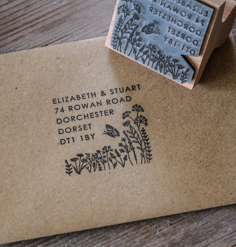 以下が含まれることがあります： 花柄のデザインと「ELIZABETH & STUART 74 ROWAN ROAD DORCHESTER DORSET DT1 1BY」という文字が印刷された黒と白のゴム印です。