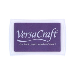 May include: A purple ink pad with the text "VersaCraft" and "For fabric, paper, wood and more!" in white lettering.