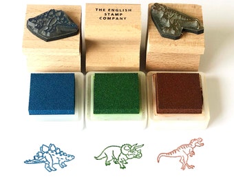 Conjunto de três carimbos de borracha de dinossauros: Estegossauro, Tiranossauro Rex e Brontossauro para artesanato e confecção de cartões infantis.