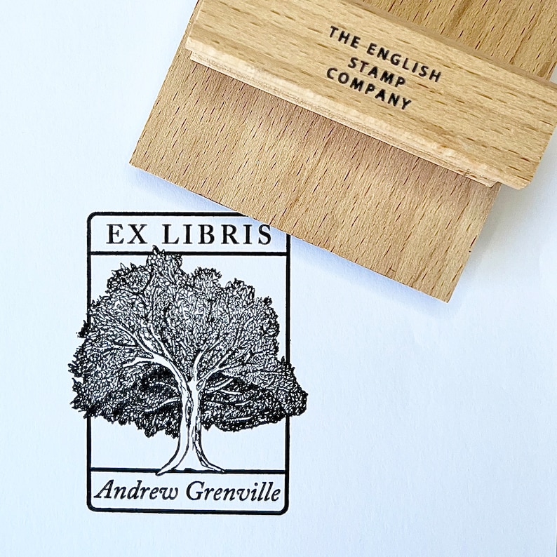 May include: Black and white stamp with a tree and the text "Ex Libris Andrew Grenville". The stamp is on a wooden block with the text "The English Stamp Company".