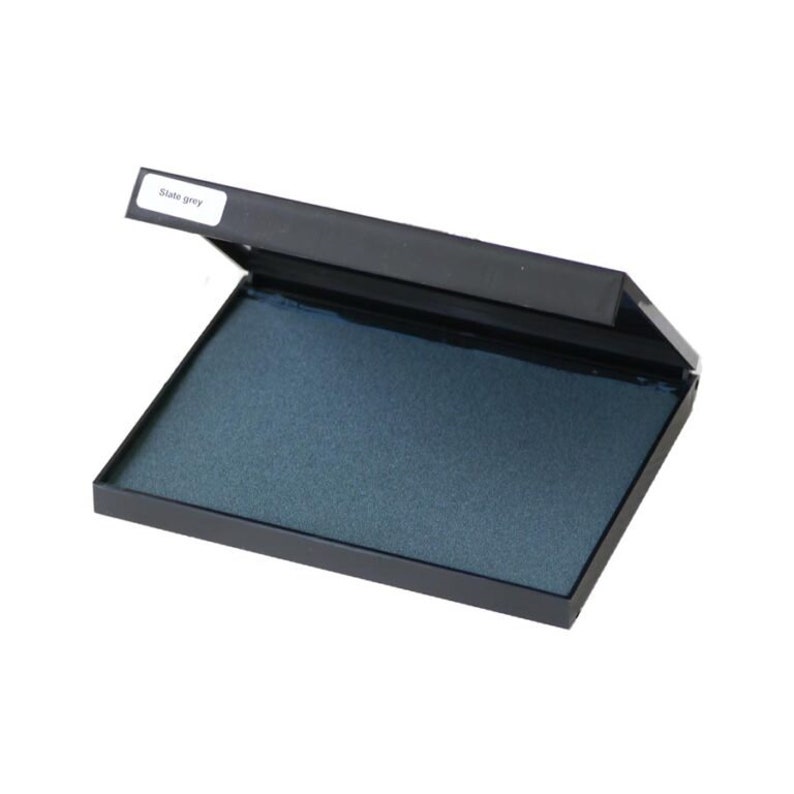 May include: A slate grey ink pad in a black plastic case. The case is open and the ink pad is visible. The label on the case says "Slate grey".