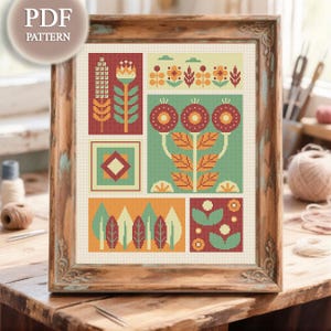 Puede incluir: Un patrón de punto de cruz enmarcado con diseños florales geométricos en tonos de rojo, naranja, verde y amarillo. La obra de arte se muestra en un marco de madera rústico. El texto "PDF PATTERN" está en la esquina superior izquierda.