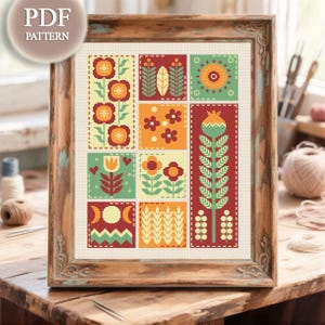 May include: A framed cross-stitch pattern featuring nine colorful floral designs in squares. The color palette includes red, orange, green, and yellow. The frame is a distressed wood with a PDF pattern label in the upper left corner.