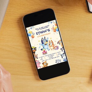 May include: A smartphone displays a birthday party invitation featuring the characters Bluey and Bingo. The invitation includes the text "Ethan's 6th Birthday!" with party details and cartoon illustrations of the characters and balloons.