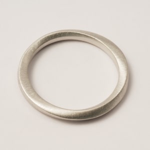 Peut inclure: Une bague simple en argent avec une surface lisse et légèrement arrondie.
