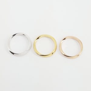 May include: Three simple, twisted metal bands in silver, gold, and rose gold.