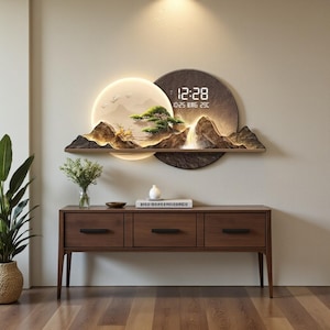 May include: A decorative wall clock with a landscape design. The clock features a digital display showing the time, date, and temperature. The design includes a mountain scene with a waterfall, a tree, and a glowing moon. The clock is mounted above a wooden cabinet.