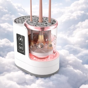 Puede incluir: Un limpiador de brochas de maquillaje blanco y oro rosa con tres brochas insertadas. El dispositivo tiene una cámara transparente con agua y burbujas, y una luz rosa en la base. El fondo es un cielo nublado.