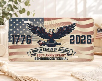 May include: A rectangular metal license plate featuring a distressed American flag background. A central bald eagle holds a torch. The text reads 1776, 2026, UNITED STATES OF AMERICA, 250th ANNIVERSARY, and SEMIQUINCENTENNIAL in dark blue and red lettering.