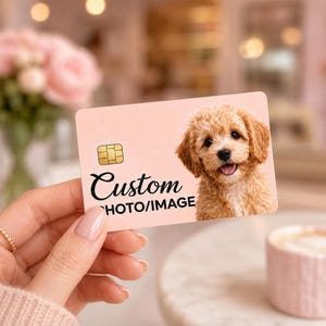 May include: A light pink custom card with a golden chip and a photo of a smiling, fluffy, light brown dog. The word "Custom" is written in black script above "PHOTO/IMAGE". The card is being held by a person.