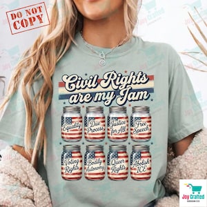 Op de afbeelding: Lichtblauw T-shirt met de tekst "Civil Rights are my Jam". Onder de tekst staan acht weckpotten met de Amerikaanse vlag en woorden als "Equality" en "Free Speech".
