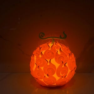 Puede incluir: Esfera naranja brillante con diseño de llama y tallo verde. Emite una luz cálida, posiblemente un objeto decorativo o una lámpara. El diseño detallado y el color vibrante crean un efecto visual llamativo.