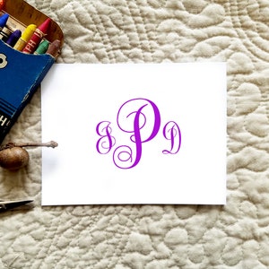 May include: A white card with a purple monogram of the letters "S P D" in a script font.