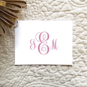 May include: A white card with a pink monogram of the letters "E & M" in a script font.
