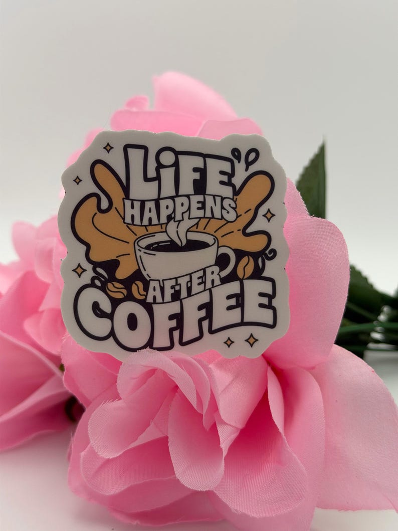 May include: A white die-cut sticker featuring a black and tan graphic of a coffee cup with steam rising. The text reads "LIFE HAPPENS AFTER COFFEE" in bold, stylised black lettering. The design includes small star accents and a coffee bean icon.