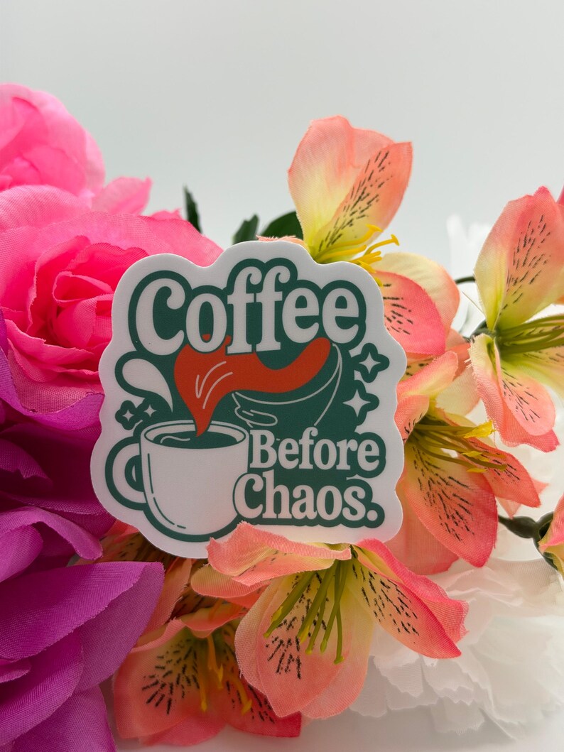 May include: A die-cut sticker featuring a white coffee mug with a dark green outline and a red liquid splash. The text reads Coffee Before Chaos in dark green retro-style lettering, accented with small star shapes against a white background.