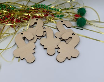 May include: A set of four light-colored wooden cutouts in the shape of candy canes with bows. Each piece features a small hole at the top for hanging. The wooden ornaments are arranged in a cluster, showcasing a smooth, unfinished surface.