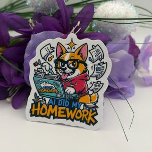 May include: A die-cut sticker featuring a cartoon corgi wearing black glasses and a red hoodie, typing on a teal laptop. The screen displays the text AI DID MY HOMEWORK, and the same phrase appears in large bold letters at the bottom.