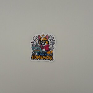 May include: A die-cut sticker featuring a cartoon corgi wearing black glasses and a red hoodie, typing on a laptop. The screen displays the text AI DID MY HOMEWORK. Floating papers surround the dog, and the text AI DID MY HOMEWORK appears in bold yellow letters at the bottom of the sticker design.