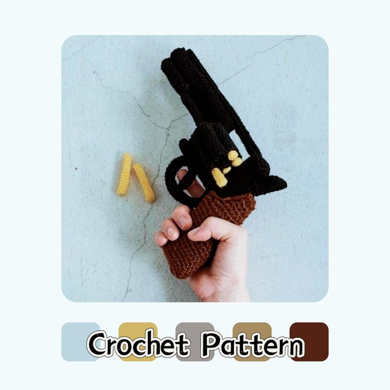 K&ouml;nnte beinhalten: Eine geh&auml;kelte Spielzeugpistole in Schwarz, Braun und Gelb, vor einem hellblauen Hintergrund. Die Pistole hat ein detailliertes Design mit einem braunen Griff und gelben Akzenten. Der Text "Crochet Pattern" befindet sich unten.