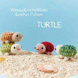 May include: Several crocheted turtle figurines in various colors, including green, red, and tan, are arranged on a sandy surface. The word "TURTLE" is written in white capital letters. The text "WinniesCrochetWorld Crochet Pattern" is also visible.