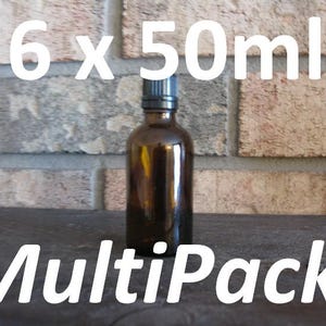 May include: Amber glass bottle with a black cap, labeled "6 x 50ml MultiPack!" against a brick background. The bottle is cylindrical and appears to be empty. The text is in white, and the overall aesthetic is simple and functional.