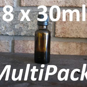 May include: A brown glass bottle with a black cap, containing a liquid. The image shows the text "8 x 30ml" and "MultiPack!" in white. The bottle is positioned in front of a brick wall.