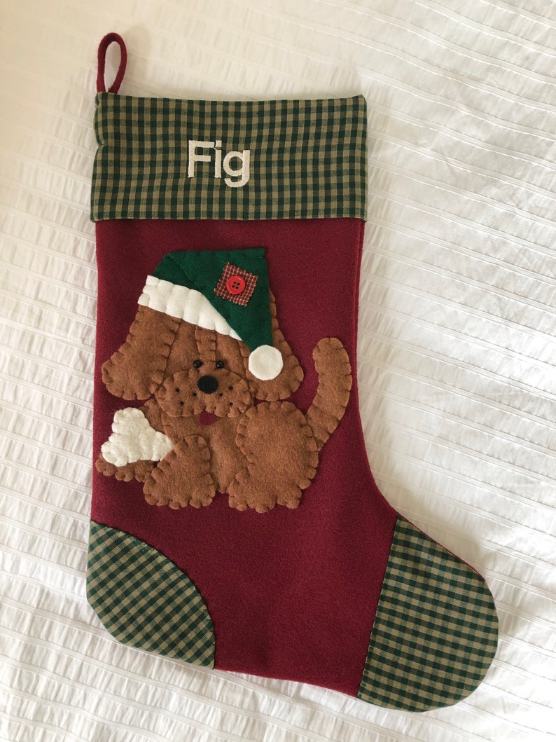 Beautiful dog stocking handmade in the US. This adorable stocking has a dog handstitched to the front of the stocking. The dog stocking is sure to be treasured for years to come. Treat your furry friend with their very own dog stocking.