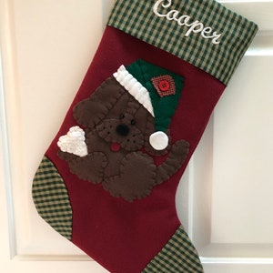 Beautiful dog stocking handmade in the US. This adorable stocking has a dog handstitched to the front of the stocking. The dog stocking is sure to be treasured for years to come. Treat your furry friend with their very own dog stocking.