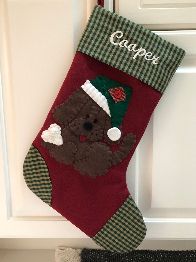 Beautiful dog stocking handmade in the US. This adorable stocking has a dog handstitched to the front of the stocking. The dog stocking is sure to be treasured for years to come. Treat your furry friend with their very own dog stocking.