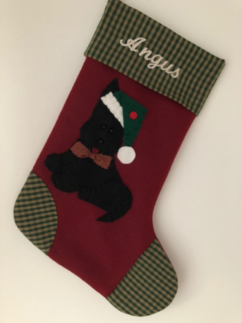 Terrier Christmas Stocking. Dog Christmas stocking with an adorable terrier on the front. Dog is wearing a stocking cap and hand stitched to the front. Stocking is made of high quality felt, lined, personalized and hangs beautifully. Optional colors