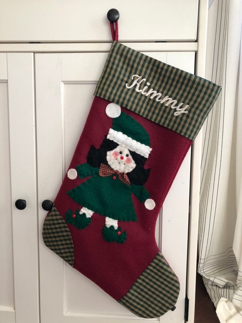 Christmas stocking with a girl elf hand-stitched to the front. Multiple hair colors to choose from. This Elf Christmas stocking is made of high quality felt, lined, personalized and hangs beautifully. Christmas stocking to treasure for years to come.