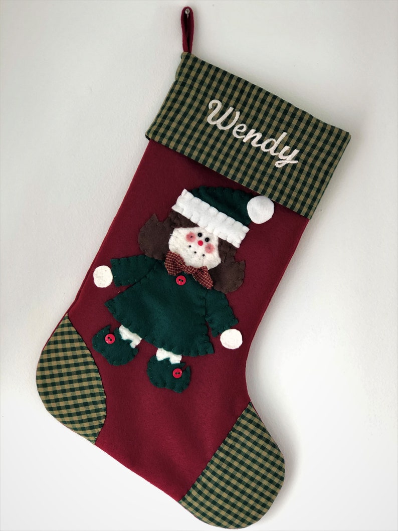 Christmas stocking with a girl elf hand-stitched to the front. Multiple hair colors to choose from. This Elf Christmas stocking is made of high quality felt, lined, personalized and hangs beautifully. Christmas stocking to treasure for years to come.