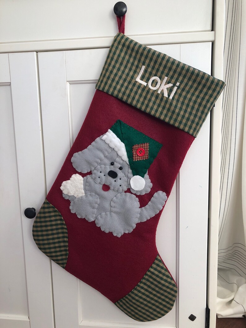 Beautiful dog stocking handmade in the US. This adorable stocking has a dog handstitched to the front of the stocking. The dog stocking is sure to be treasured for years to come. Treat your furry friend with their very own dog stocking.