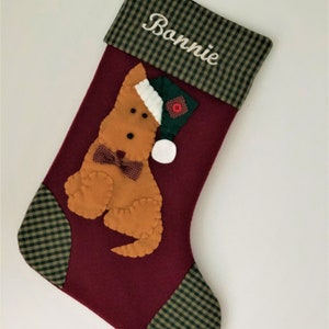 Terrier Christmas Stocking. Dog Christmas stocking with an adorable terrier on the front. Dog is wearing a stocking cap and hand stitched to the front. Stocking is made of high quality felt, lined, personalized and hangs beautifully. Optional colors