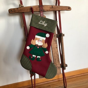 Christmas stocking with a girl elf hand-stitched to the front. Multiple hair colors to choose from. This Elf Christmas stocking is made of high quality felt, lined, personalized and hangs beautifully. Christmas stocking to treasure for years to come.