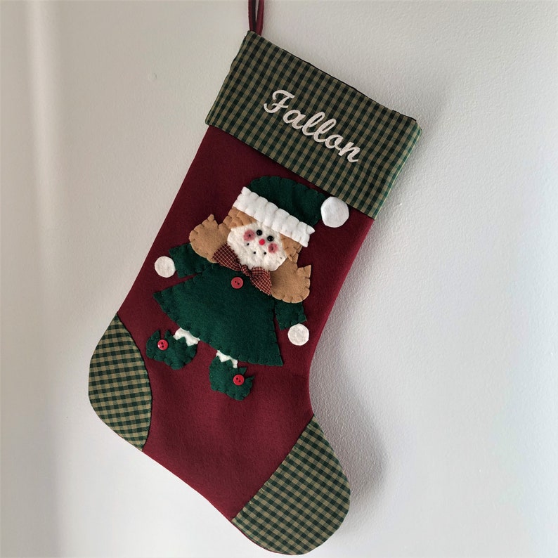 Christmas stocking with a girl elf hand-stitched to the front. Multiple hair colors to choose from. This Elf Christmas stocking is made of high quality felt, lined, personalized and hangs beautifully. Christmas stocking to treasure for years to come.